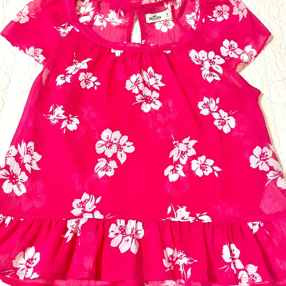 Hollister Small sheer pink top (not red), embellished with a bow in The back.EUC